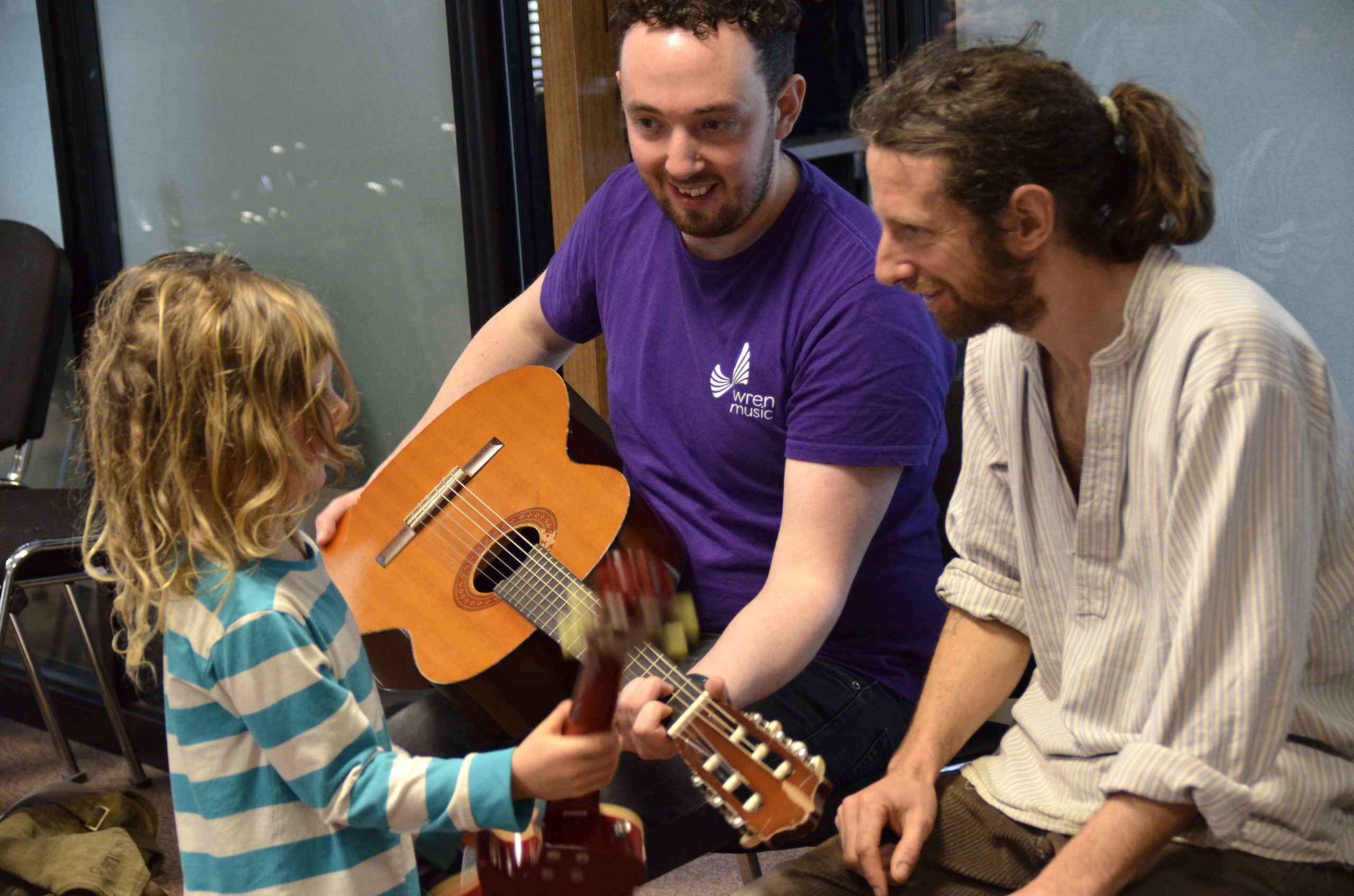 Jon Dyer of Wren Music with guitar, dad and daughter